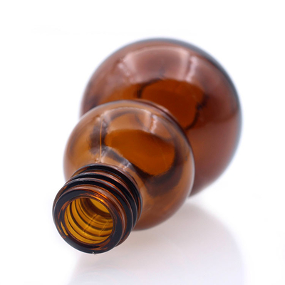 La cucúrbita ambarina de cristal del color de la botella de aceite esencial formó